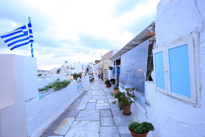 Oia l&agrave; điểm đến cuối c&ugrave;ng trong ng&agrave;y của ch&uacute;ng t&ocirc;i. Nơi đ&acirc;y được mệnh danh l&agrave; địa điểm ngắm ho&agrave;ng h&ocirc;n đẹp nhất thế giới. Từ 16h, ch&uacute;ng t&ocirc;i đ&atilde; c&oacute; mặt tại l&agrave;ng, loanh quanh tr&ecirc;n những bậc đ&aacute; uyển chuyển, điệu đ&agrave; dưới t&aacute;n hoa giấy, b&ecirc;n những ng&ocirc;i nh&agrave; tường trắng m&aacute;i v&agrave; cổng xanh nổi tiếng.